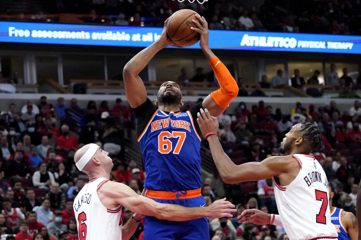New York Knicks center Taj Gibson (C) rebounds the ball against Chicago Bulls guard Alex Caruso (L) and forward Troy Brown Jr. during the first half of an NBA basketball game in Chicago on Oct. 28, 2021. (Nam Y. Huh/AP Photo)