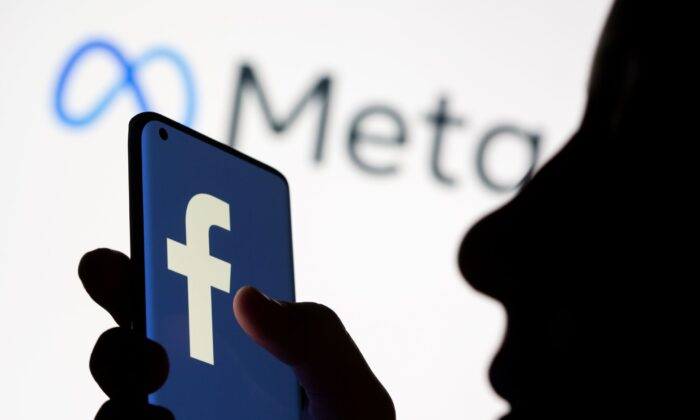 A woman holds a smartphone with the Facebook logo in front of Facebook's new rebrand logo Meta in this illustration picture taken on Oct. 28, 2021. (Dado Ruvic/Reuters)