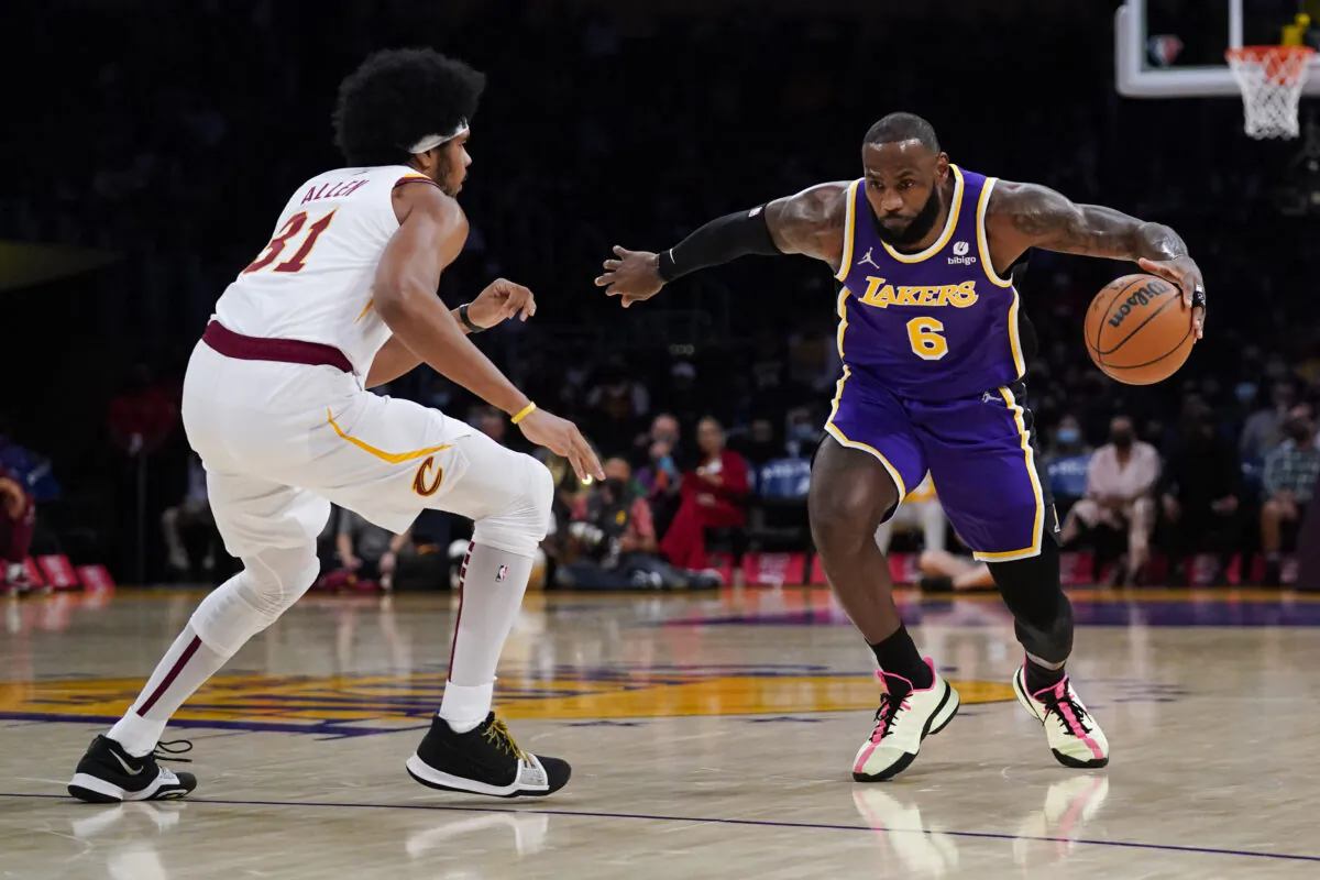 Los Angeles Lakers' LeBron James, right, drives around Cleveland Cavaliers' Jarrett Allen during the first half of an NBA basketball game in Los Angeles on Oct. 29, 2021. (AP Photo/Jae C. Hong)