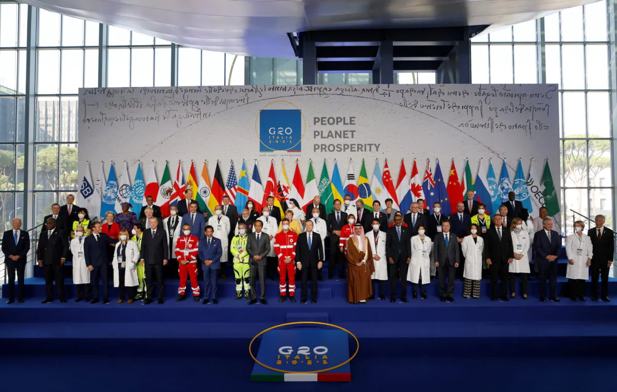 World leaders pose with Italian medical team members for a group photograph on day one of the G20 leaders summit in Rome, Italy, on Oct. 30, 2021. (Ludovic Marin/Pool via Reuters)