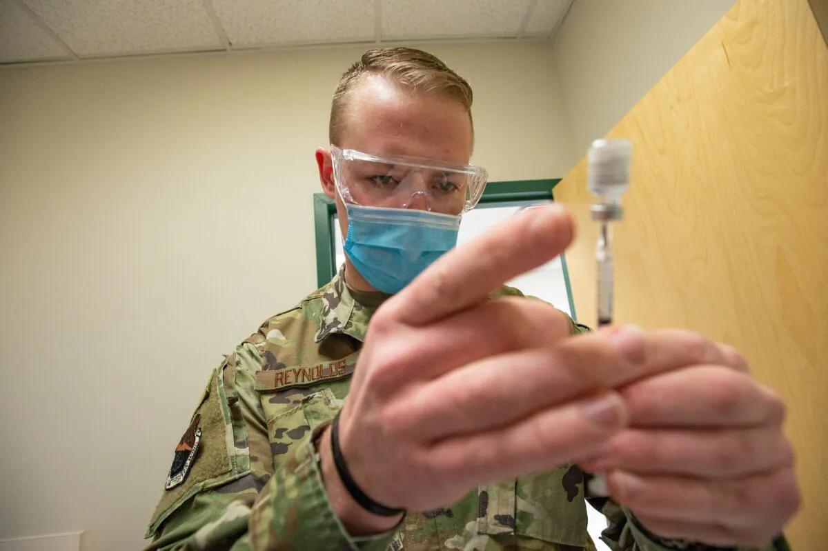 A U.S. Air Force staff sergeant handles a Pfizer COVID-19 vaccine at a clinic in Massachusetts on Feb. 16, 2021. (Joseph Prezioso/AFP via Getty Images)