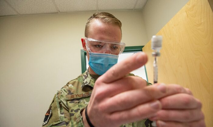 A U.S. Air Force staff sergeant handles a Pfizer COVID-19 vaccine at a clinic in Massachusetts on Feb. 16, 2021. (Joseph Prezioso/AFP via Getty Images)