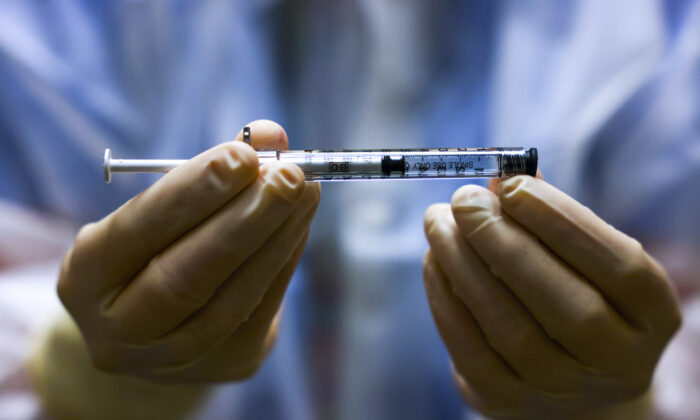 A person holds a dose of a COVID-19 vaccine in a clinical trial in Aurora, Colorado, on Dec. 15, 2020. (Michael Ciaglo/Getty Images)