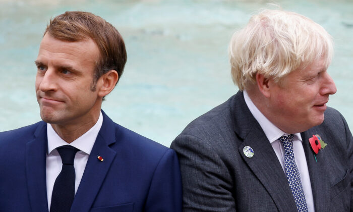 Britain's Prime Minister Boris Johnson and French President Emmanuel Macron in front of the Trevi Fountain during the G20 summit in Rome, on Oct. 31, 2021. (Guglielmo Mangiapane/Reuters)
