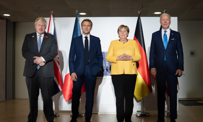 (L–R) British Prime Minister Boris Johnson, French President Emmanuel Macron, German Chancellor Angela Merkel, and U.S. President Joe Biden pose for the media prior to a meeting at the La Nuvola conference center for the G-20 summit in Rome on Oct. 30, 2021. (Stefan Rousseau/Pool/Getty Images)