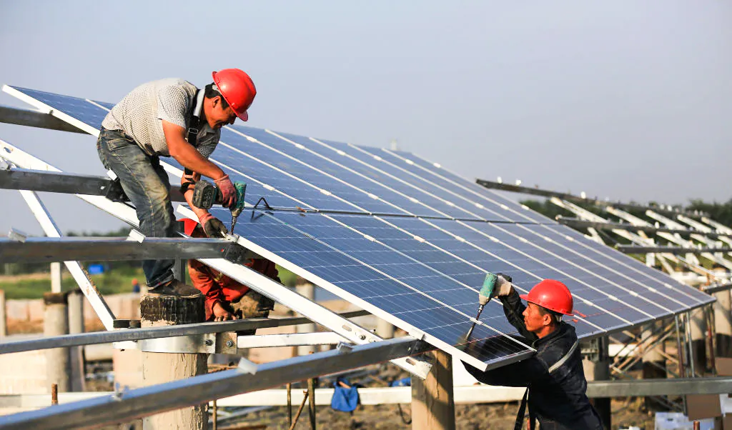 Workers install solar panels at the construction site of the 40MW photovoltaic on-grid power project in Huai'an, China, on June 11, 2018. (VCG/VCG via Getty Images)