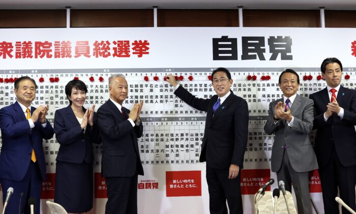 Japan's Prime Minister and ruling Liberal Democratic Party leader Fumio Kishida (3rd-right) poses with key party members as he puts rosettes by successful general election candidates' names on a board at the party headquarters in Tokyo, Japan, on Oct. 31, 2021. (Behrouz Mehri/Pool via AP)