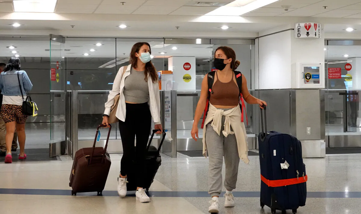 Travelers exit from the International arrivals door at Miami International Airport in Miami, Fla., on Sept. 20, 2021. (Joe Raedle/Getty Images)