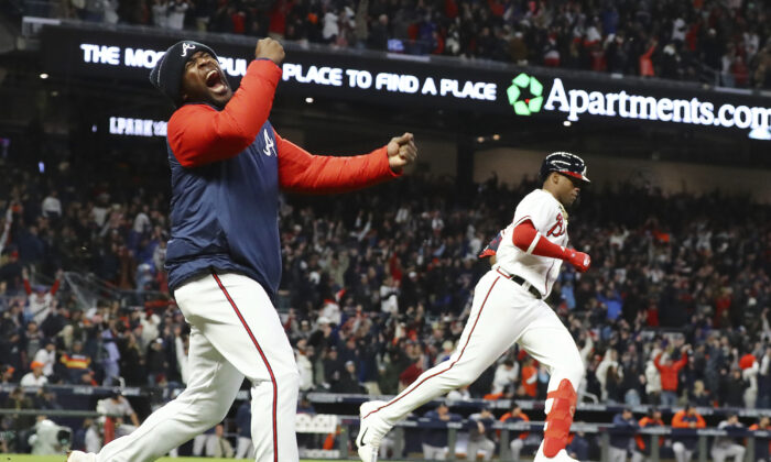 Braves Jorge Soler rounds the bases on his go-ahead solo homer as Guillermo Heredia comes out of the dugout to cheer during the game winner for a 3–2 lead over the Astros in game 4 of the World Series in Atlanta, Ga., on Oct. 30, 2021. (Curtis Compton/Atlanta Journal-Constitution via AP)