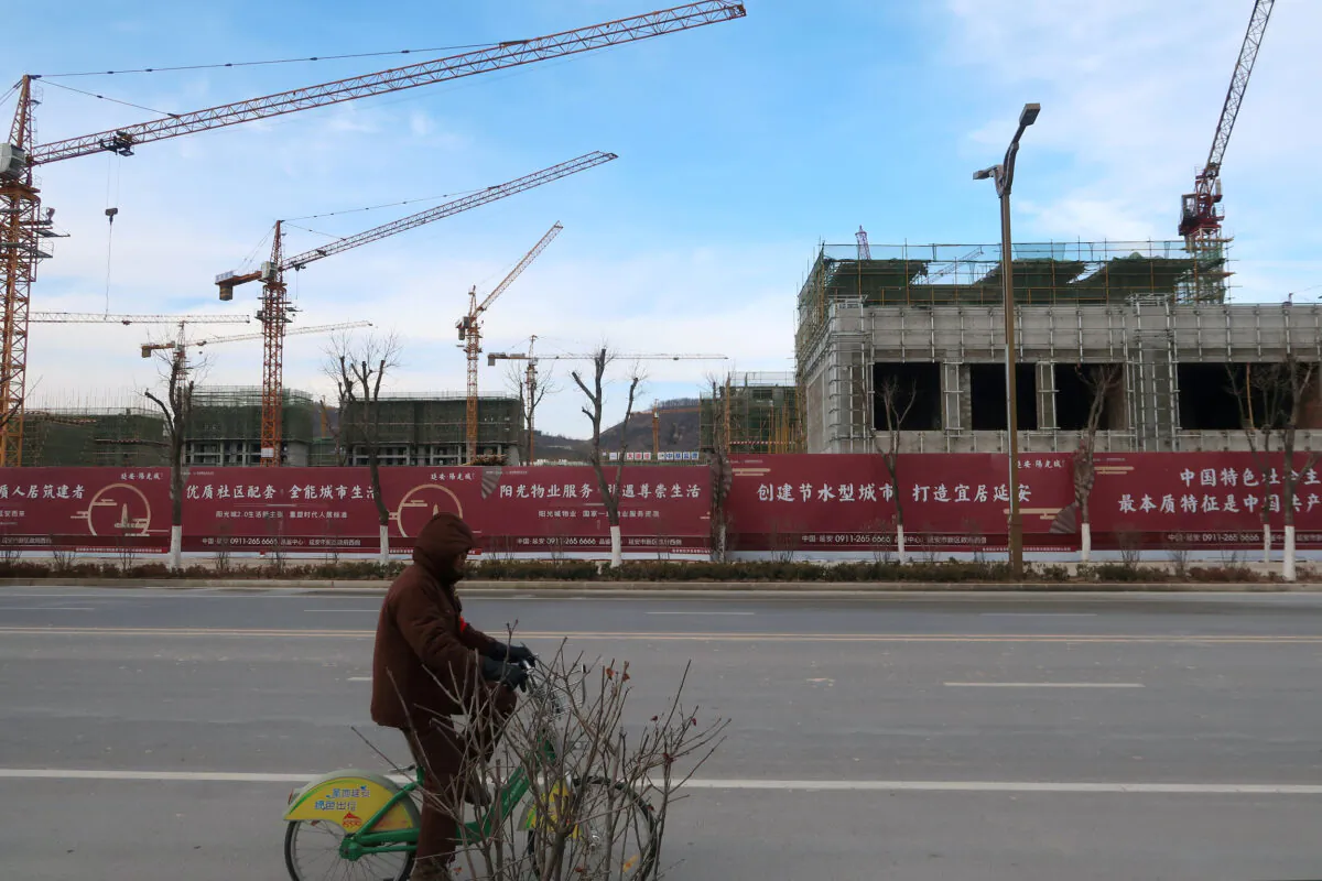 A man rides a bicycle past a Yango Group real estate project under construction in Yanan New Zone, Shaanxi province, China, on Jan. 4, 2019. (Yawen Chen/Reuters)