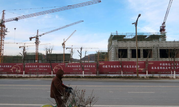 A man rides a bicycle past a Yango Group real estate project under construction in Yanan New Zone, Shaanxi province, China, on Jan. 4, 2019. (Yawen Chen/Reuters)