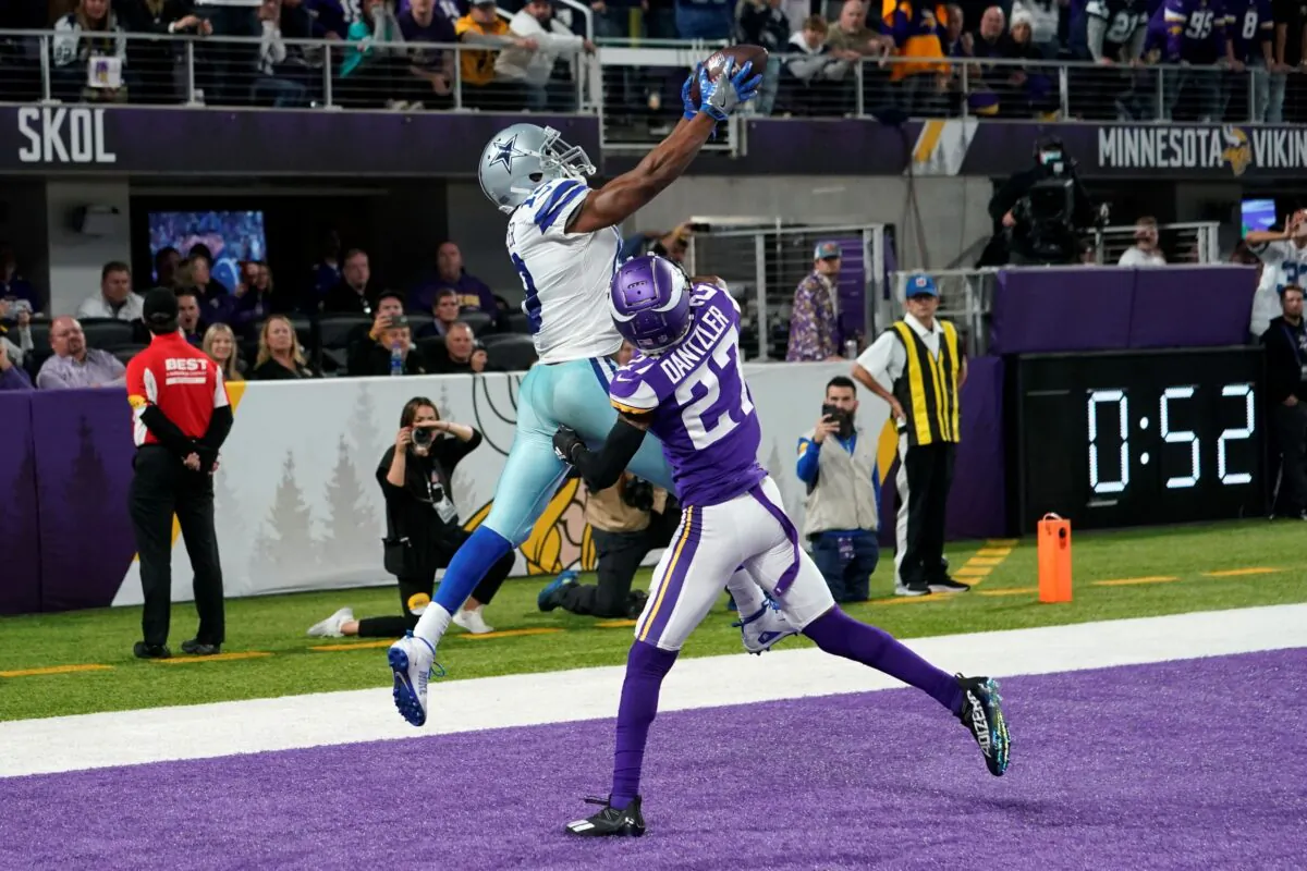 Dallas Cowboys wide receiver Amari Cooper (19) catches a 5-yard touchdown pass over Minnesota Vikings cornerback Cameron Dantzler (27) during the second half of an NFL football game in Minneapolis, Minn., on Oct. 31, 2021. (Jim Mone/AP Photo)