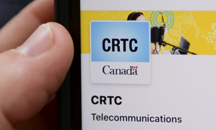 A person navigates to the on-line social-media pages of the Canadian Radio-television and Telecommunications Commission (CRTC) on a cell phone in Ottawa on May 17, 2021. (The Canadian Press/Sean Kilpatrick)