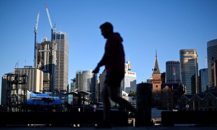 The Sydney skyline is seen as a man walks past in Circular Quay, usually packed with tourists, in Sydney, Australia, on June 16, 2020. (Saeed Khan/AFP via Getty Images)
