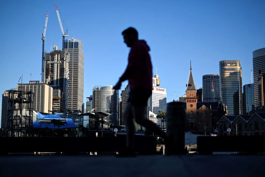 The Sydney skyline is seen as a man walks past in Circular Quay, usually packed with tourists, in Sydney, Australia, on June 16, 2020. (Saeed Khan/AFP via Getty Images)