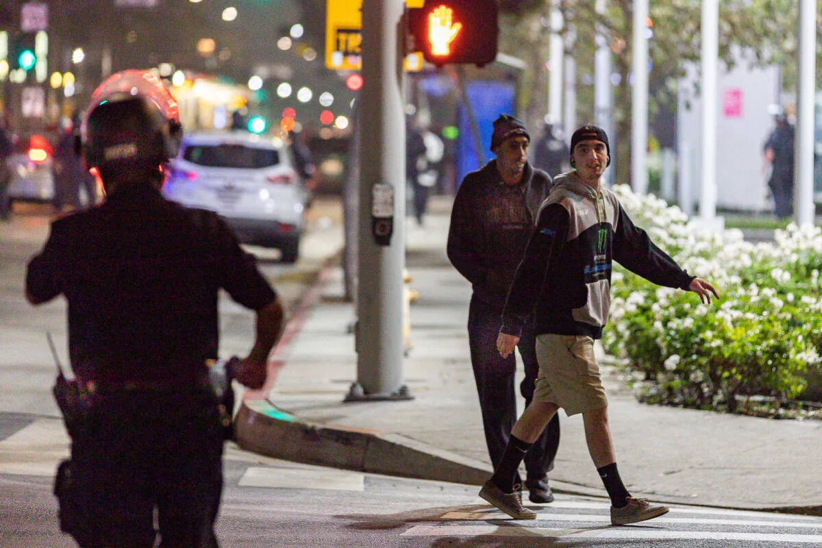Men taunt a Los Angeles Police Department officer with profanity in Los Angeles, Calif., on Nov. 6, 2020. (John Fredricks/The Epoch Times)