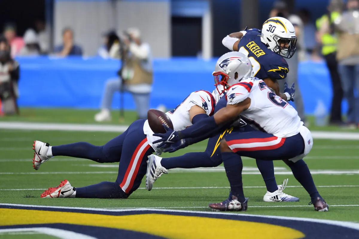 New England Patriots safety Adrian Phillips (R) intercepts a pass intended for Los Angeles Chargers running back Austin Ekeler (30) during the first half of an NFL football game in Inglewood, Calif., on Oct. 31, 2021. (John McCoy/AP Photo)