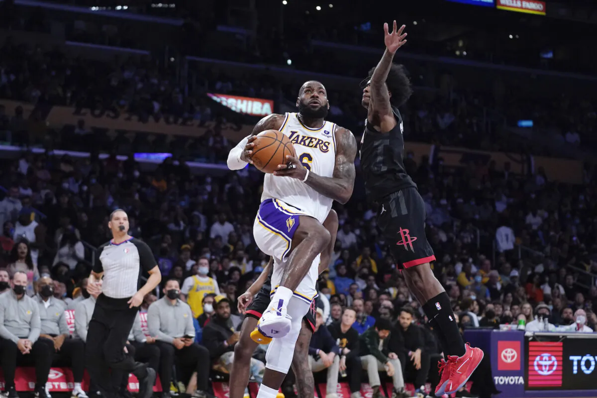 Los Angeles Lakers forward LeBron James, left, shoots as Houston Rockets guard Kevin Porter Jr. defends during the first half of an NBA basketball game in Los Angeles on Oct. 31, 2021. (AP Photo/Mark J. Terrill)