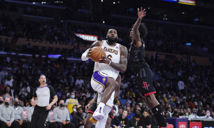 Los Angeles Lakers forward LeBron James, left, shoots as Houston Rockets guard Kevin Porter Jr. defends during the first half of an NBA basketball game in Los Angeles on Oct. 31, 2021. (AP Photo/Mark J. Terrill)
