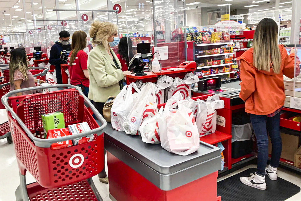 A customer wears a mask as she waits to get a receipt at a register in a Target store in Vernon Hills, Ill., Sunday, May 23, 2021. (AP Photo/Nam Y. Huh)
