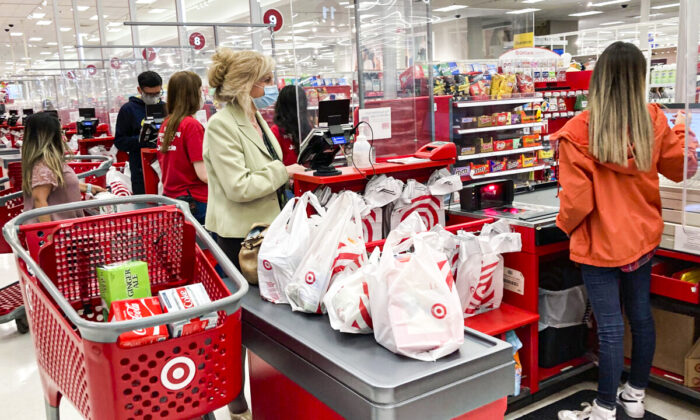 A customer wears a mask as she waits to get a receipt at a register in a Target store in Vernon Hills, Ill., Sunday, May 23, 2021. (AP Photo/Nam Y. Huh)
