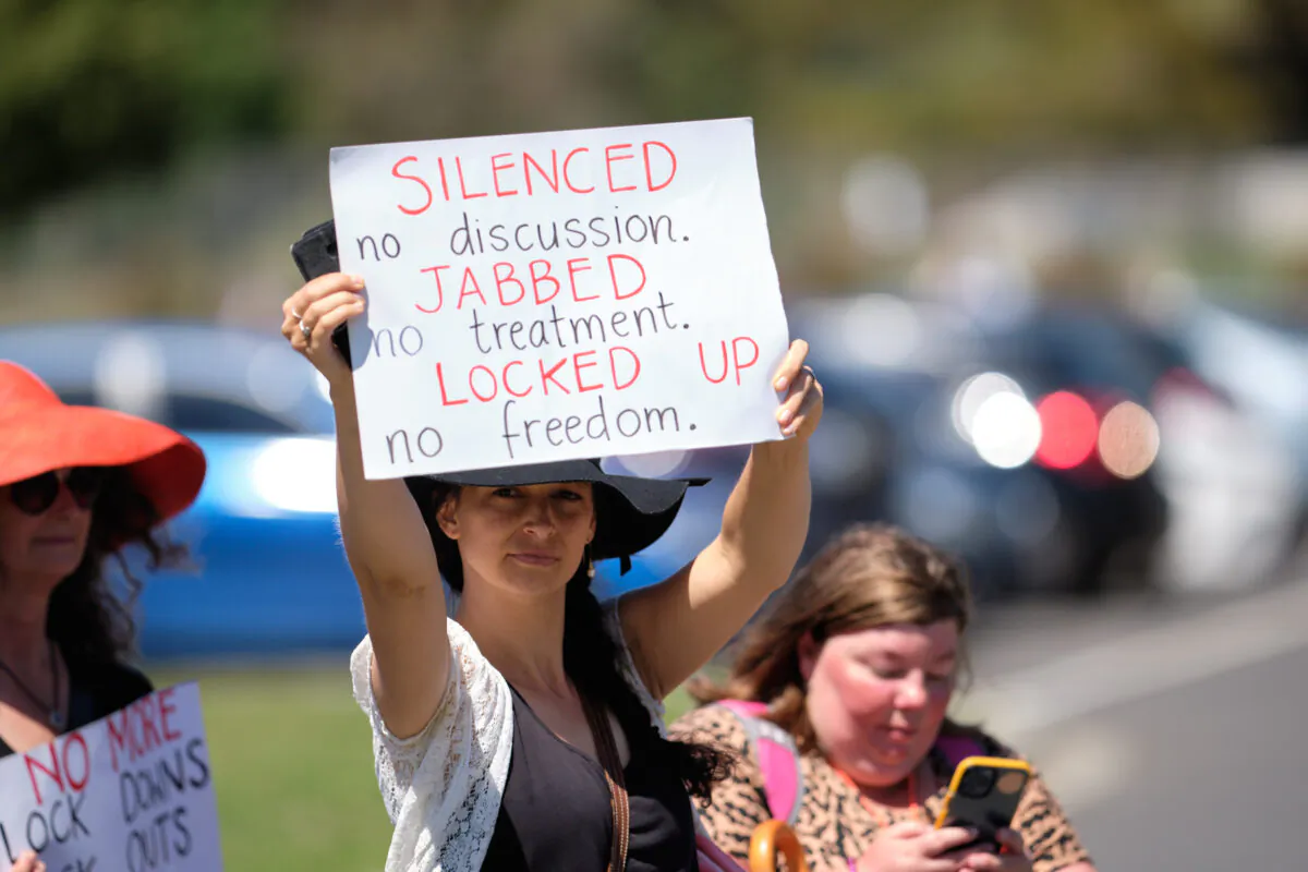 A protestor holds up a sign during rallies against government-mandated health restrictions and impending Pandemic legislation in Melbourne, Australia, on Nov. 2, 2021. (Supplied)