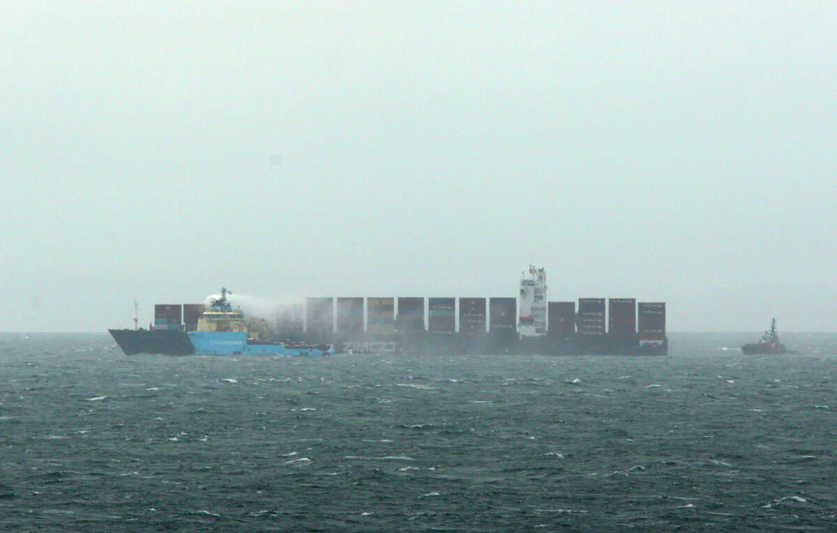 Ships continue to work to control a fire onboard the MV Zim Kingston about eight kilometres from the shore in Victoria, B.C., on Oct. 25, 2021. (The Canadian Press/Chad Hipolito)