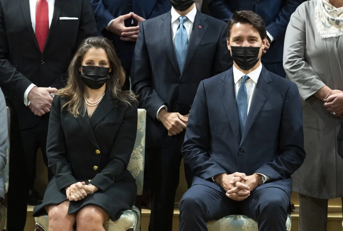 Prime Minister Justin Trudeau is seated beside Deputy Prime Minister and Minister of Finance Chrystia Freeland as they pose for a group photo with members of the federal cabinet after a swearing in ceremony at Rideau Hall in Ottawa, on Oct. 26, 2021. (The Canadian Press/Justin Tang) 