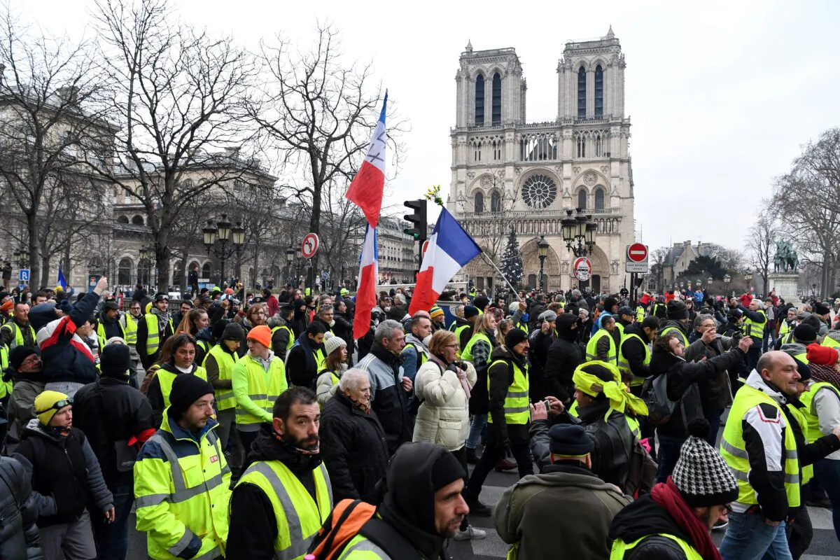 Yellow vest protestors walk in front of Notre-Dame cathedral in Paris on Jan. 5, 2019. (Eric Feferberg /AFP via Getty Images)