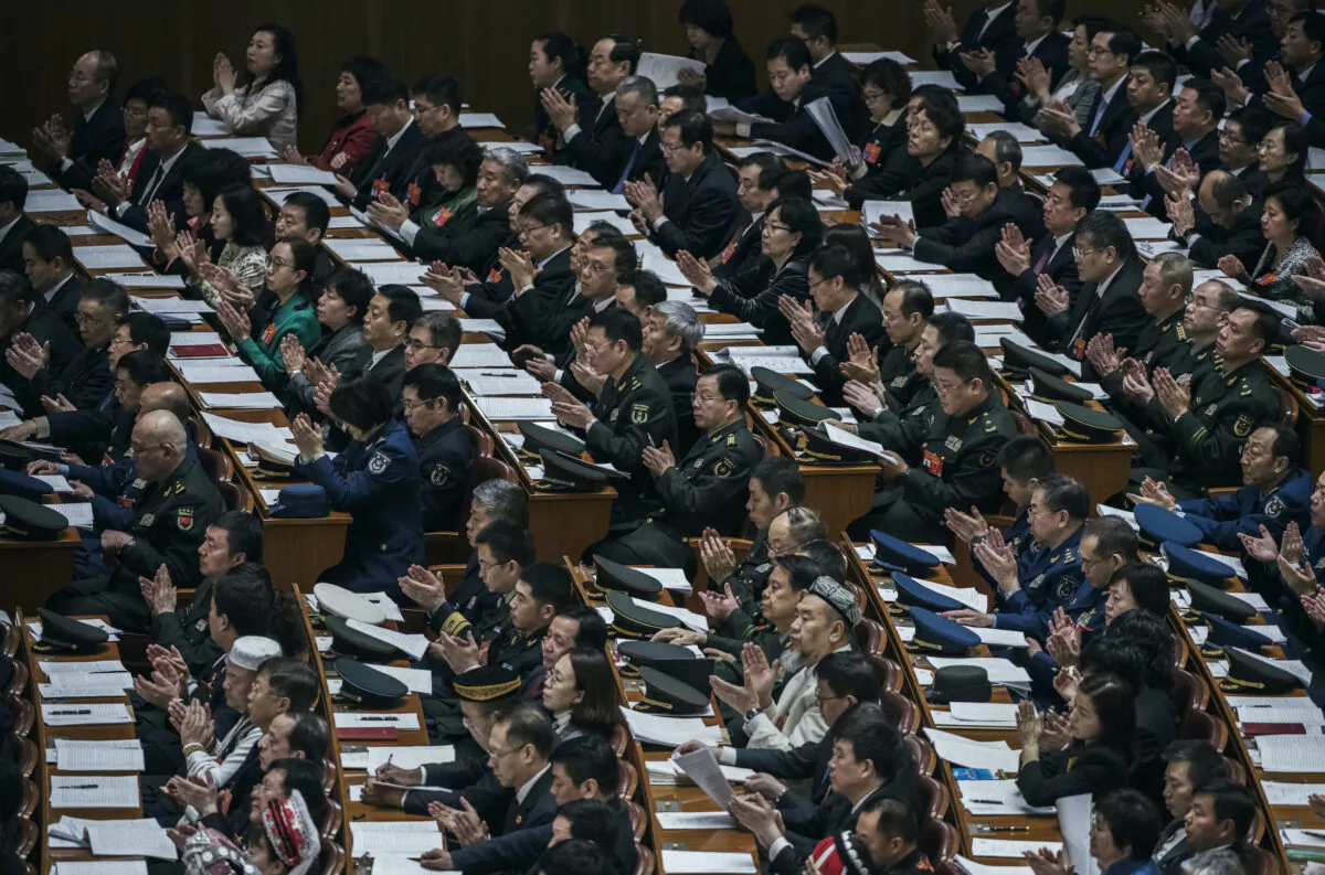 Delegates applaud during the third plenary session of the National People's Congress at the Great Hall of the People in Beijing on March 12, 2019. (Kevin Frayer/Getty Images)