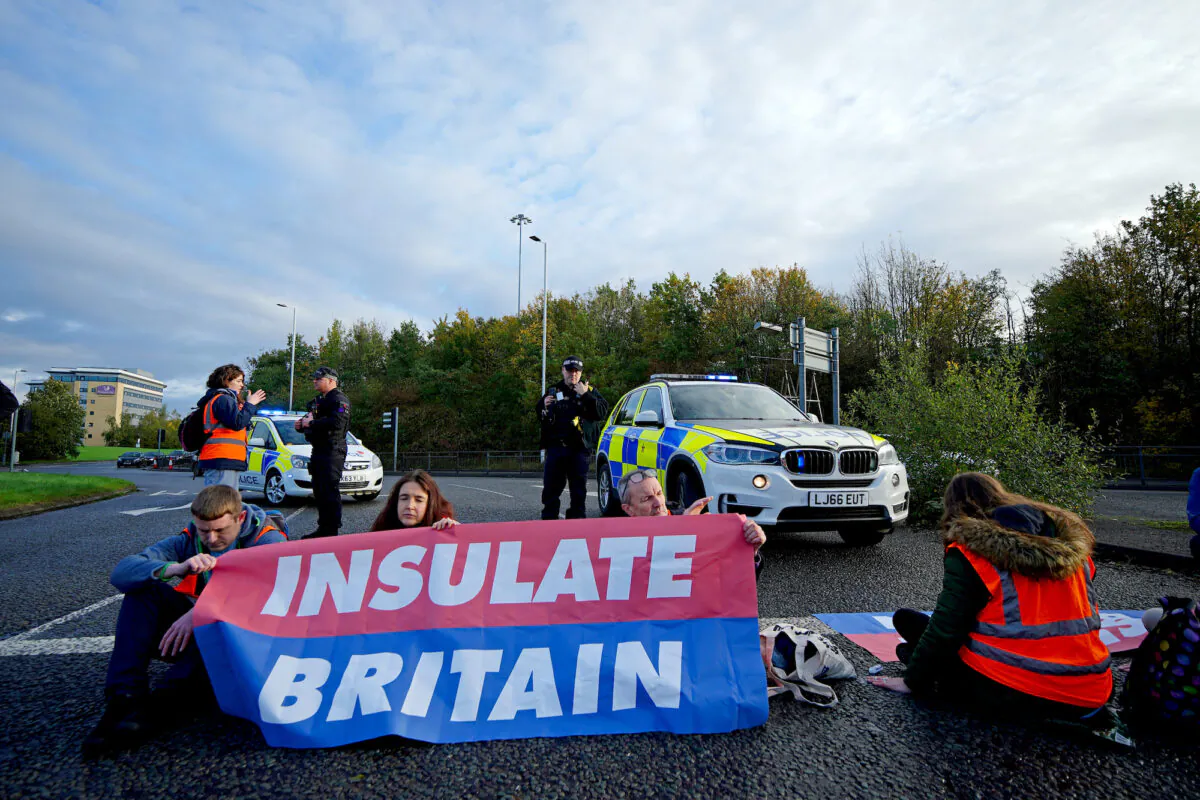 Protesters from Insulate Britain blocking a road near to the Holiday Inn Express Motorway Airport in Manchester, England on Nov. 2, 2021. (Peter Byrne/PA)