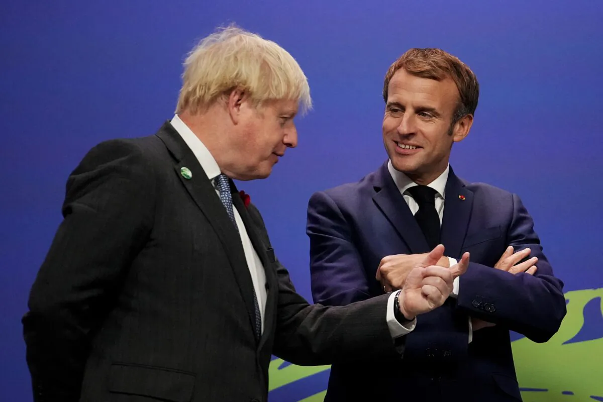 UK Prime Minister Boris Johnson greets French President Emmanuel Macron as he arrives to attend the COP26 U.N. Climate Change Conference in Glasgow, Scotland, on Nov. 1, 2021. (Christopher Furlong /pool/AFP via Getty Images)
