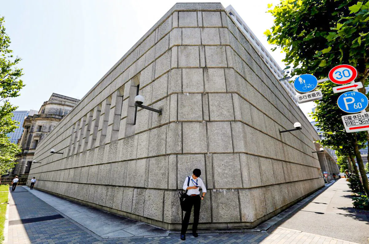 A man looks at a mobile phone in front of the Bank of Japan building in Tokyo, Japan on June 16, 2017. (Toru Hanai/Reuters)