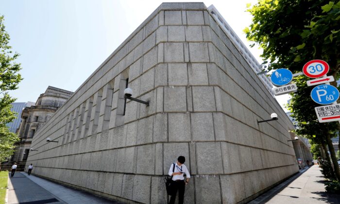 A man looks at a mobile phone in front of the Bank of Japan building in Tokyo, Japan, on June 16, 2017. (Toru Hanai/Reuters)