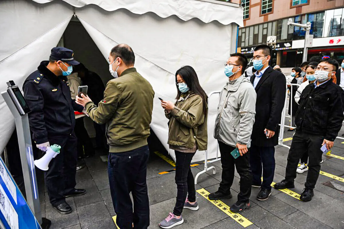 People line up to get a booster shot of a COVID-19 vaccine in a tent set up outside a shopping mall in Beijing on Nov. 1, 2021. (Greg Baker/AFP via Getty Images)