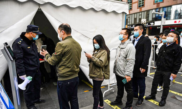 People line up to get a booster shot of a COVID-19 vaccine in a tent set up outside a shopping mall in Beijing on Nov. 1, 2021. (Greg Baker/AFP via Getty Images)