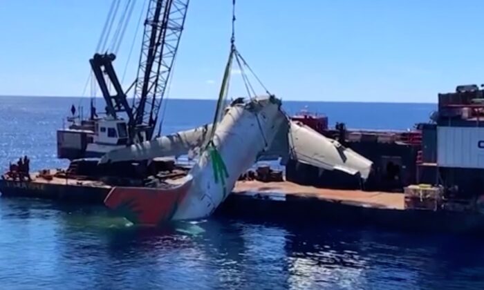  fuselage of TransAir flight 810 is being lifted out of the water onto a ship off Honolulu, Hawaii, on Oct. 30, 2021. (National Transportation Safety Board via AP/Screenshot via   Pezou)