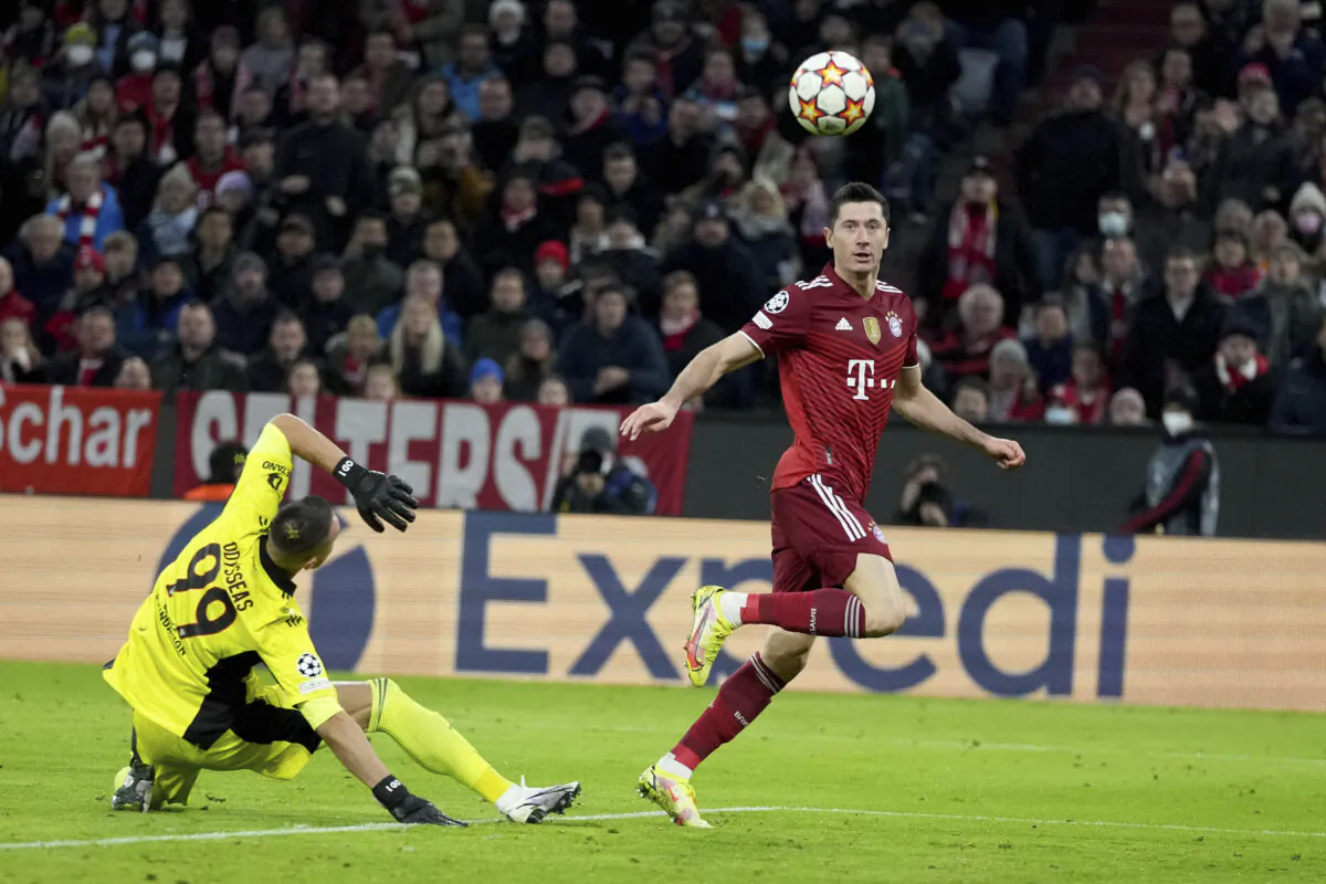 Bayern's Robert Lewandowski (R) scores his side's fourth goal during the Champions League group E soccer match between Bayern Munich and Benfica Lisbon in Munich, Germany on Nov. 2, 2021. (Matthias Schrader/AP Photo)