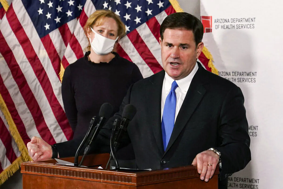 Arizona Gov. Doug Ducey answers a question about the arrival of a COVID-19 vaccine in Arizona, while Arizona Department of Health Services Director Dr. Cara Christ listens, in Phoenix, Ariz., on Dec. 2, 2020. (Ross D. Franklin, Pool/AP Photo)