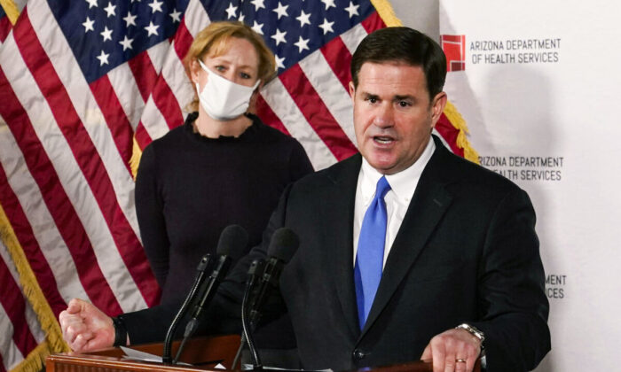 Arizona Gov. Doug Ducey answers a question about the arrival of a COVID-19 vaccine in Arizona, while Arizona Department of Health Services Director Dr. Cara Christ listens, in Phoenix, Ariz., on Dec. 2, 2020. (Ross D. Franklin/AP Photo)