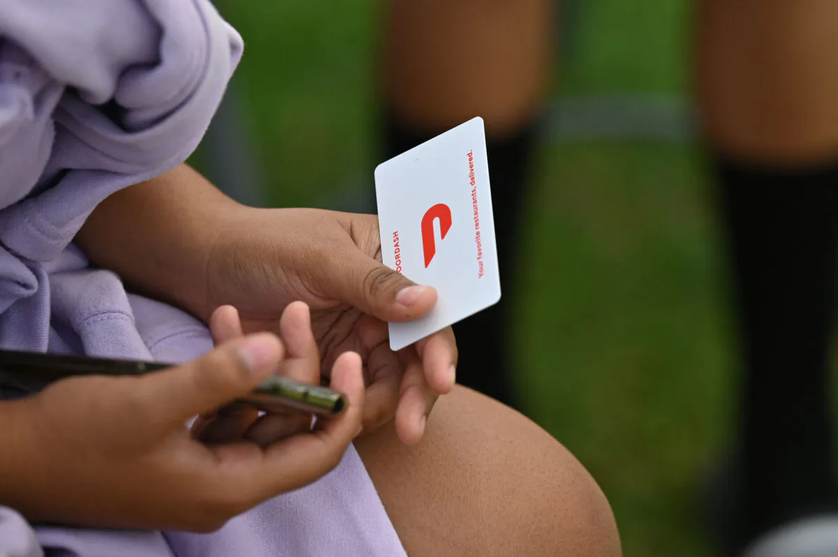 A woman holds a $25 DoorDash gift card in Los Angeles on Aug. 11, 2021. (Robyn Beck/AFP via Getty Images)