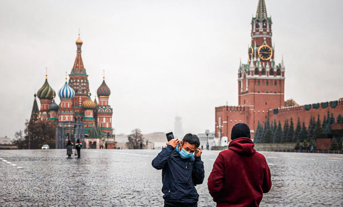 A man puts his protective face mask as he stands in a deserted Red Square amid the outbreak of the COVID-19 pandemic in Moscow on Oct. 28, 2021. (Dimitar Dilkoff/AFP via Getty Images)