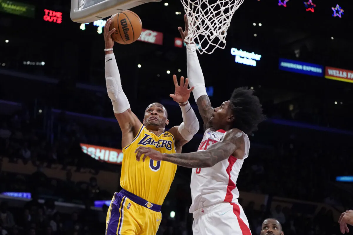 Los Angeles Lakers guard Russell Westbrook, left, drives to the basket as Houston Rockets guard Kevin Porter Jr. defends during the first half of an NBA basketball game in Los Angeles on Nov. 2, 2021. (AP Photo/Marcio Jose Sanchez)