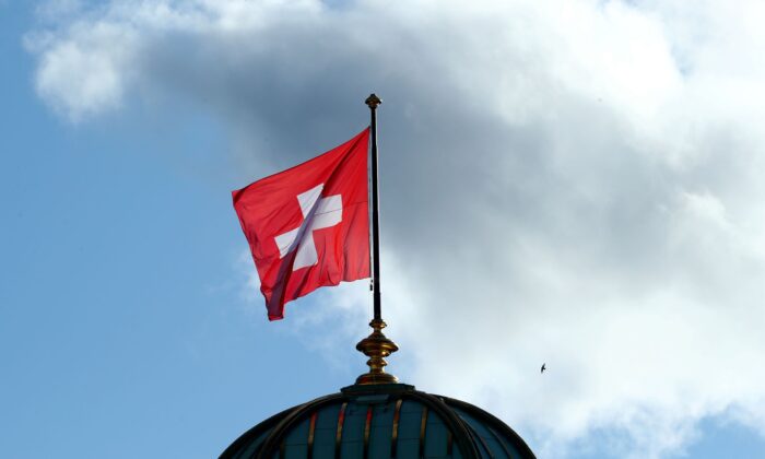 A flag flutters on the Swiss Parliament Building (Bundeshaus), after the weekly governmental meeting in Bern, Switzerland, on Nov. 27, 2019. (Denis Balibouse/Reuters)