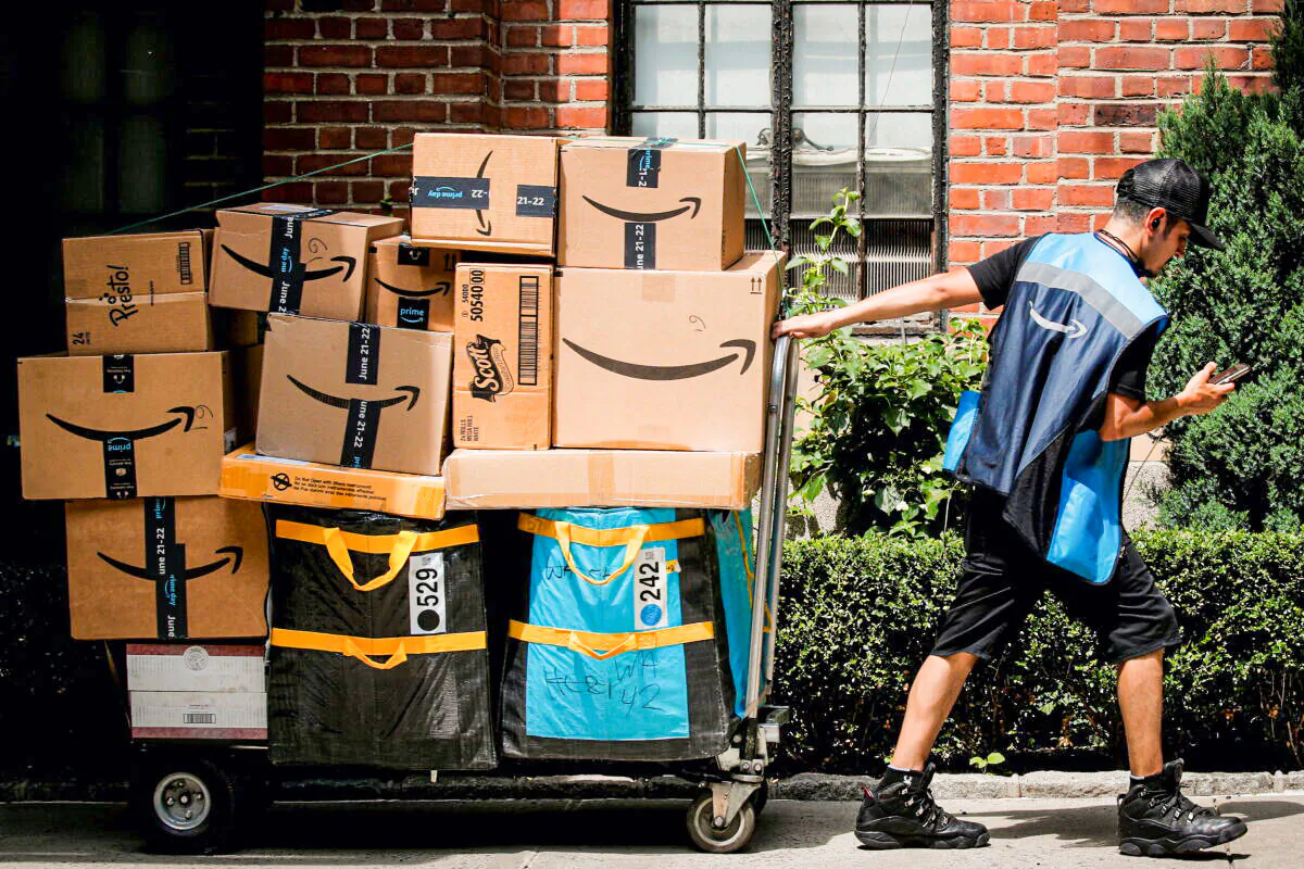 An Amazon delivery worker pulls a delivery cart full of packages in New York City on June 21, 2021. (Brendan McDermid/Reuters)