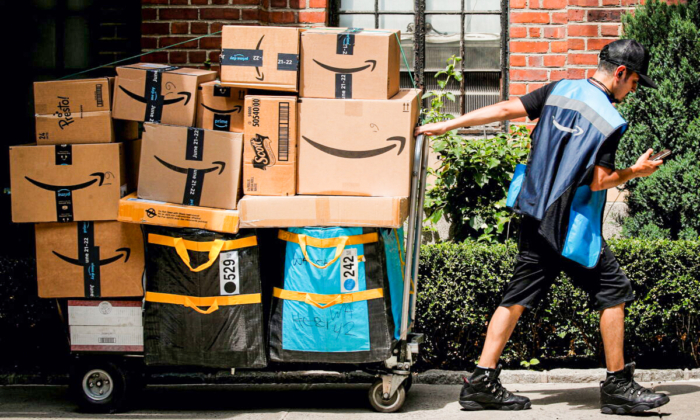 An Amazon delivery worker pulls a delivery cart full of packages during its annual Prime Day promotion in New York City, on June 21, 2021. (Brendan McDermid/Reuters)