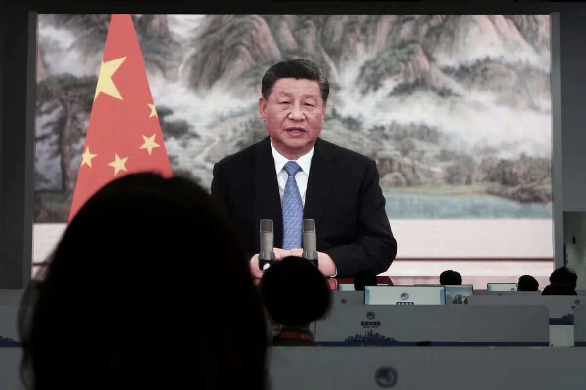 Chinese President Xi Jinping is seen on television screens at a media centre as he delivers a speech via video at the opening ceremony of the China International Import Expo (CIIE) in Shanghai, China, on Nov. 4, 2021. (Andrew Galbraith/Reuters)