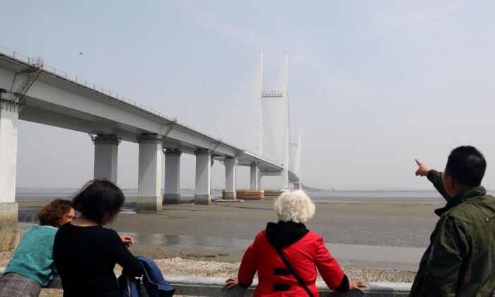 A man points at the New Yalu River Bridge designed to connect China's Dandong New Zone and North Korea's Sinuiju, in Dandong, Liaoning province, China, on April 20, 2021. (Tingshu Wang/Reuters)