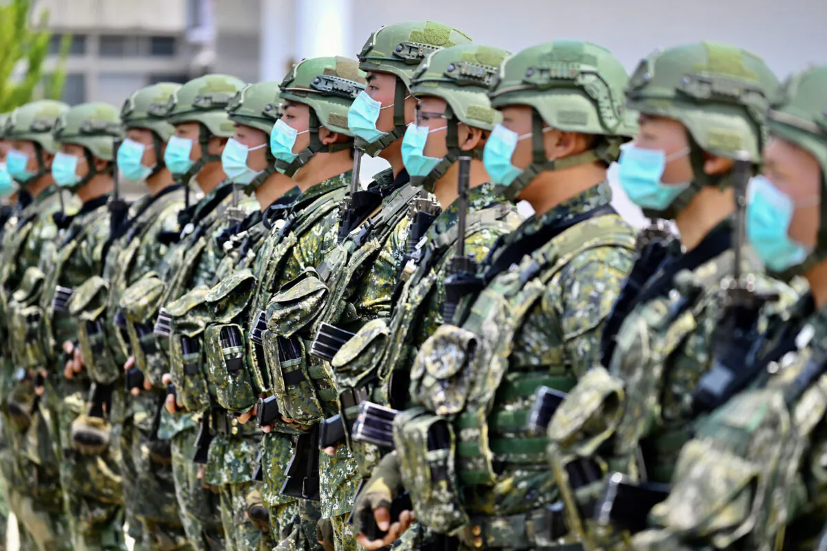 Soldiers wearing face masks amid the COVID-19 coronavirus pandemic listen to an address by Taiwan President Tsai Ing-wen during her visit to a military base in Tainan, southern Taiwan, on April 9, 2020. (Sam Yeh/AFP/Getty Images/TNS)