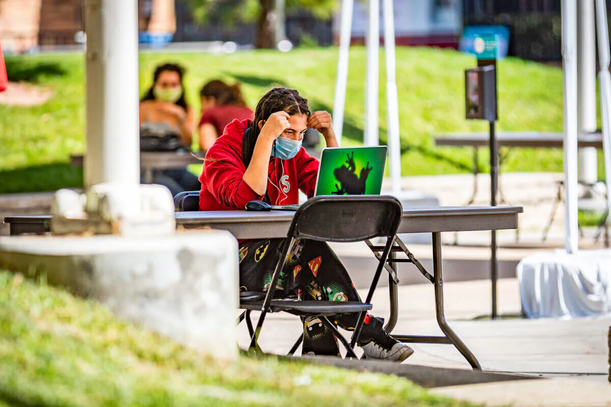 A student does work in the shade at Chapman University in Orange, Calif., on Oct. 14, 2020. (John Fredricks/The Epoch Times)